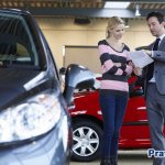 The seller hands the documents into the hands of the car buyer