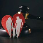 A torn heart with a family stands leaning on the judge&#39;s gavel